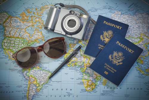 picture of a map, a camera, and passport to signify the action of travelling